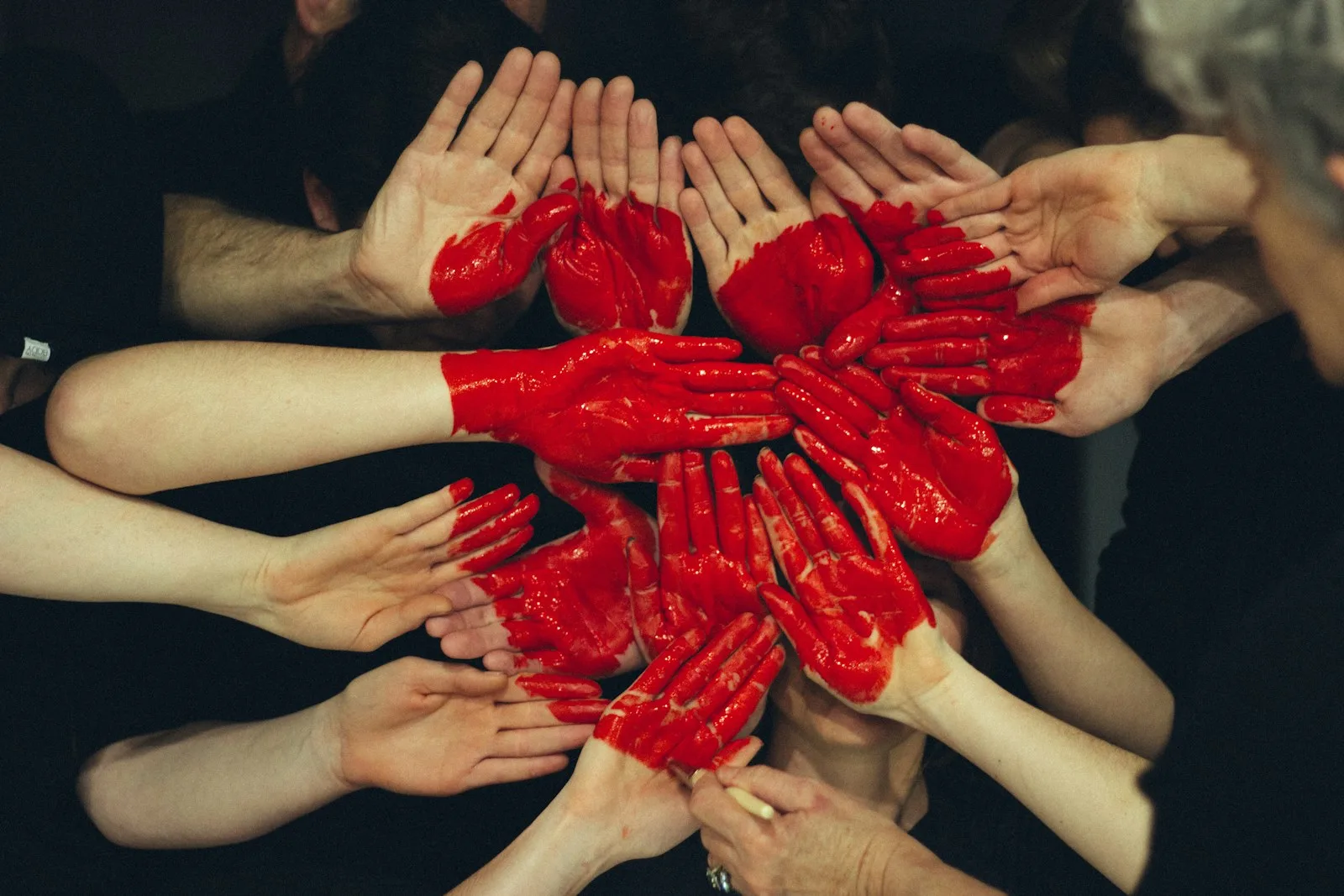A group of hands forming the sign of love. A sign of charity.