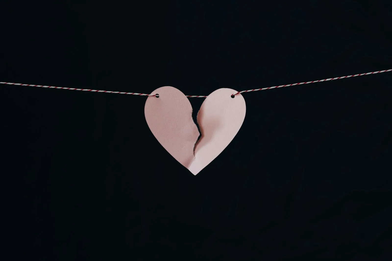 Photo of a paper which is in the shape of love, being torn apart as a sign of failure in marriage