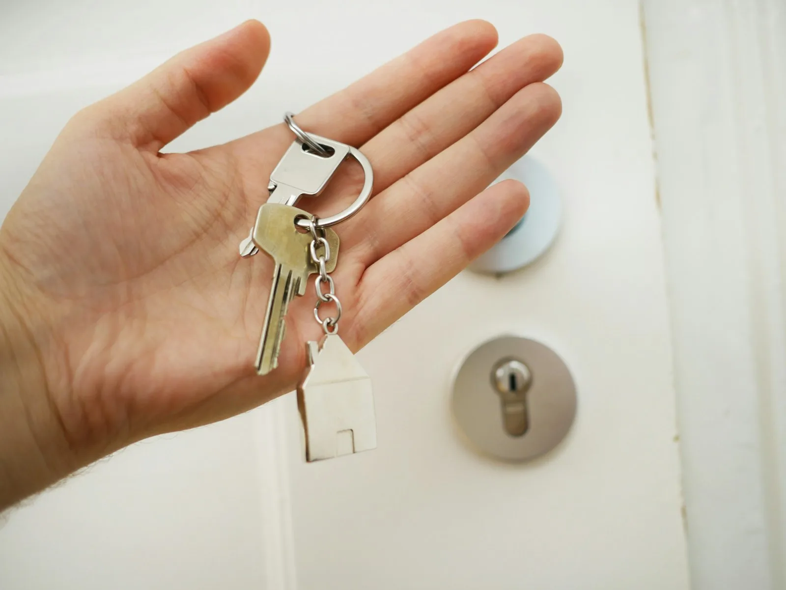 A person holding out the keys to his investment property