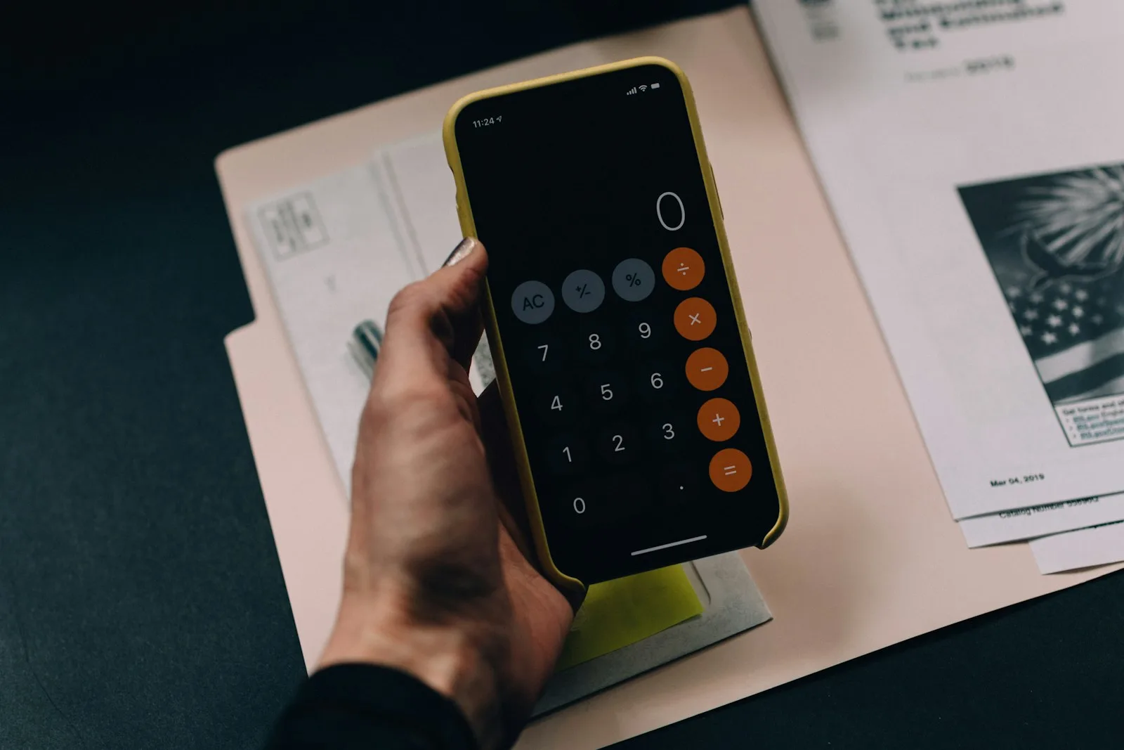 A person calculating their income with the help of a calculator