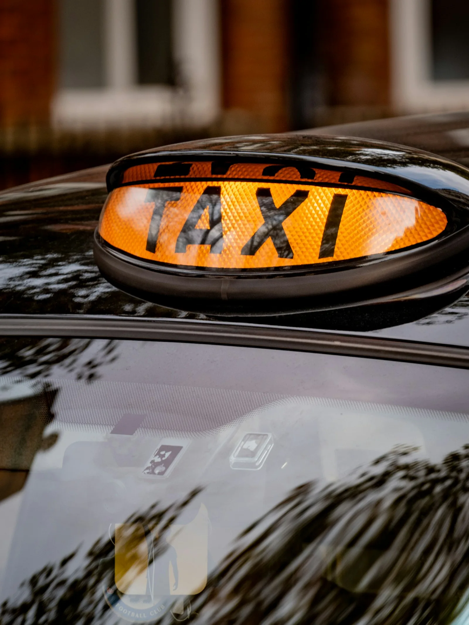 Image of TAXI sign on top of a car